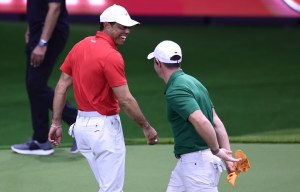 Tiger Woods and Rory McIlroy laughing during a golf match.